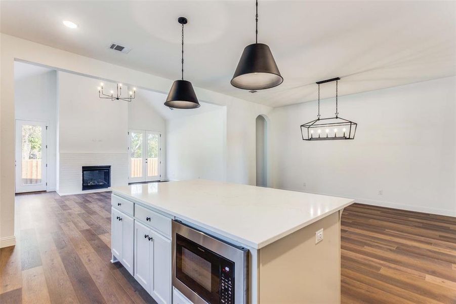 Kitchen featuring pendant lighting, plenty of natural light, and stainless steel microwave