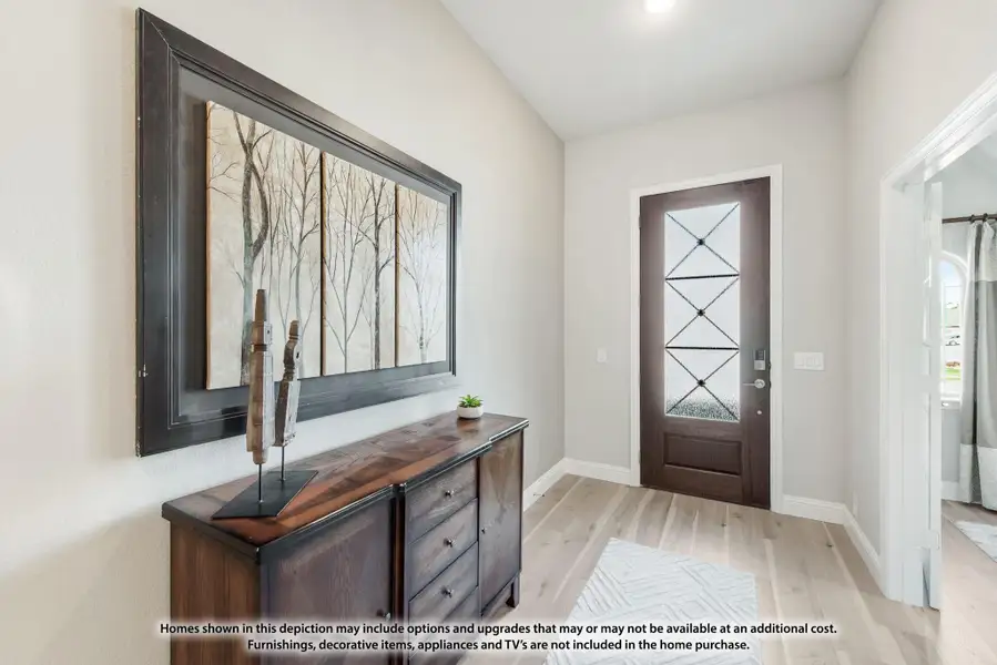 Home entryway with dark wood front door, light hardwood floors, and wood console table with wall art Home entryway with dark wood front door, light hardwood floors, and wood console table with wall art