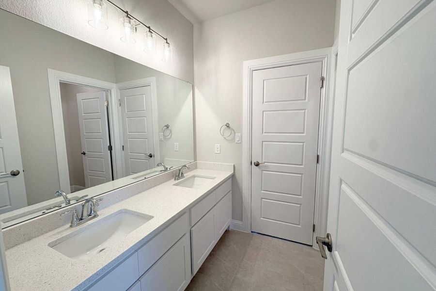 Dual vanity featuring a light-toned countertop with integrated sinks and chrome fixtures