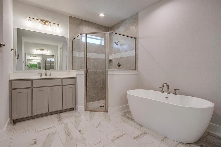 Bathroom featuring tile patterned flooring, shower with separate bathtub, and vanity