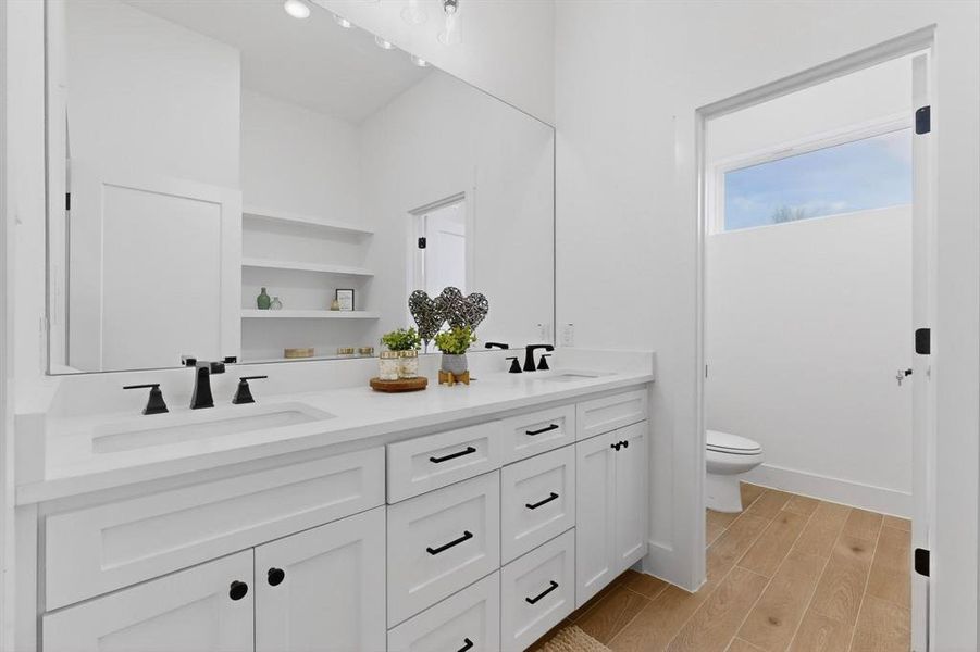 Full bath featuring wood finish floors and double vanity