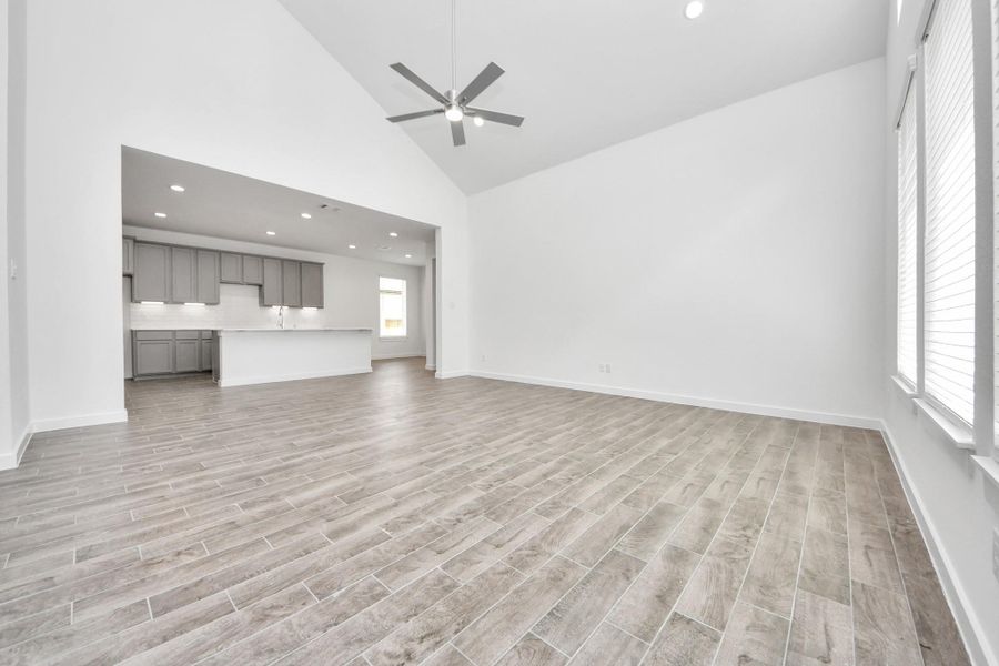 Gather the family and guests together in your lovely living room! Featuring soaring high ceilings, recessed lighting, ceiling fan, custom paint, gorgeous floors, and large windows that provide plenty of natural lighting throughout the day. Sample photo of completed home with similar floor plan. Actual colors and selections may vary. Gather the family and guests together in your lovely living room! Featuring soaring high ceilings, recessed lighting, ceiling fan, custom paint, gorgeous floors, and large windows that provide plenty of natural lighting throughout the day. Sample photo of completed home with similar floor plan. Actual colors and selections may vary.