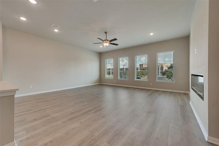 Unfurnished living room with light hardwood / wood-style floors and ceiling fan