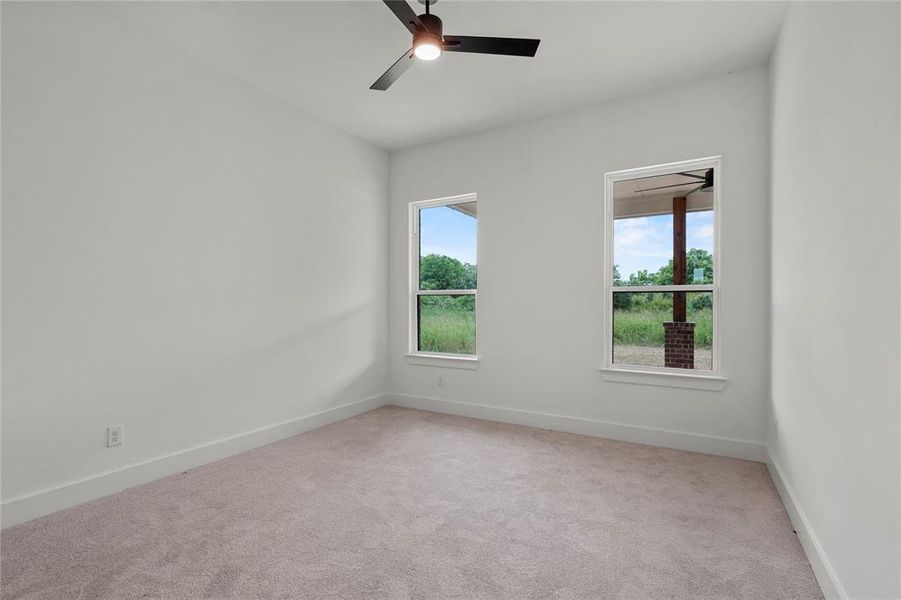 Empty room with light carpet and ceiling fan