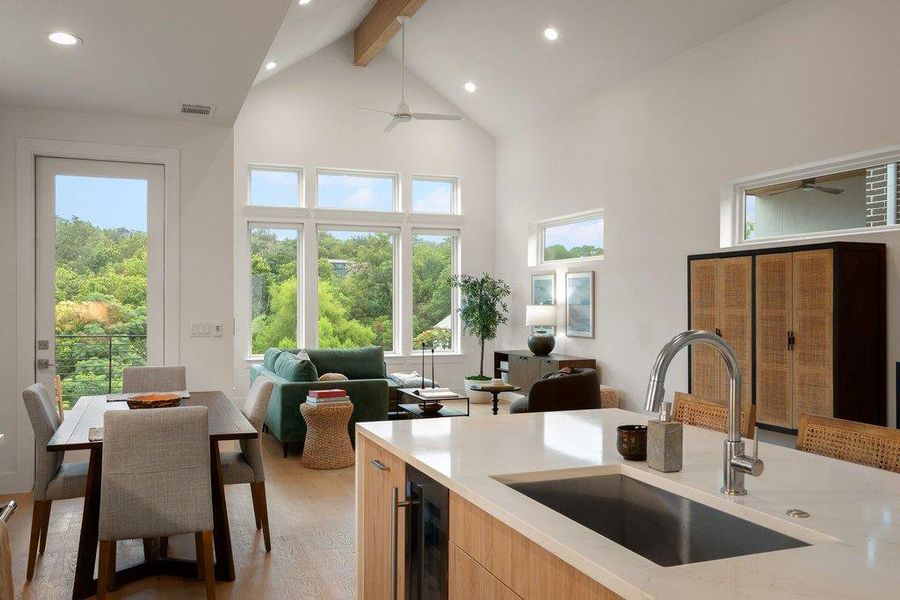 An open-concept living space with high ceilings and large windows provides verdant treetop views. An open-concept living space with high ceilings and large windows provides verdant treetop views.