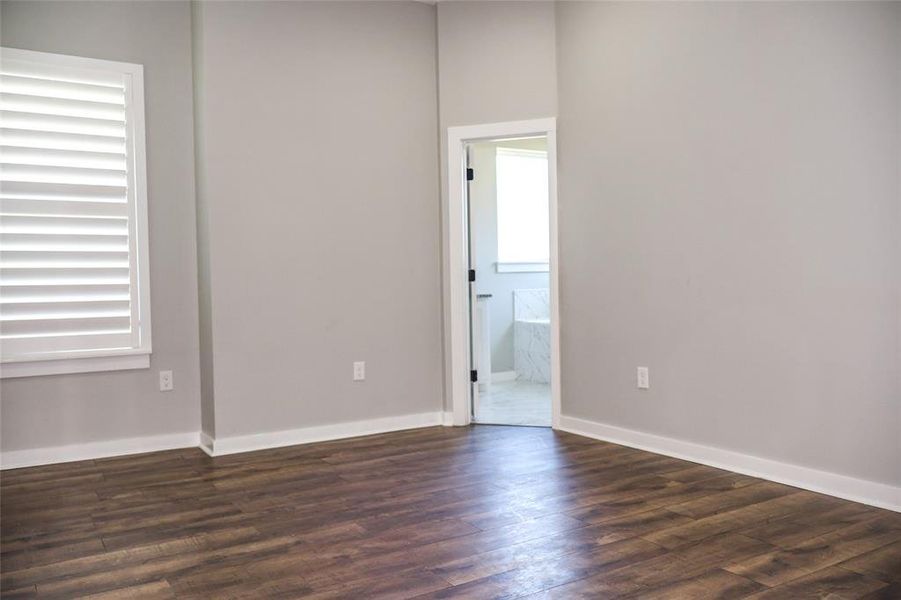 Unfurnished room with dark wood-style flooring and baseboards Unfurnished room with dark wood-style flooring and baseboards