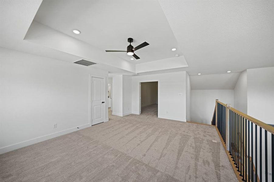 Empty room with a raised ceiling, light colored carpet, recessed lighting, and ceiling fan Empty room with a raised ceiling, light colored carpet, recessed lighting, and ceiling fan