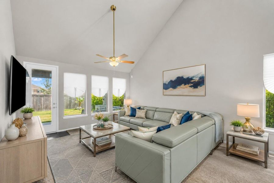 This open-concept living space boasts high vaulted ceilings, integrated recessed lighting, and large windows that fill the area with natural light.**Virtually staged This open-concept living space boasts high vaulted ceilings, integrated recessed lighting, and large windows that fill the area with natural light.**Virtually staged