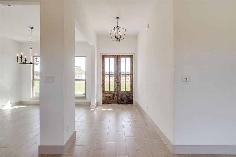 Entrance foyer featuring light hardwood / wood-style floors, a wealth of natural light, and a chandelier