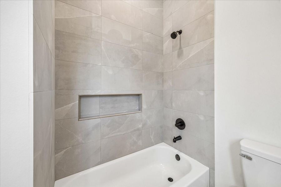Clean lines, full height tile, and built in storage niches deliver timeless style with everyday practicality.