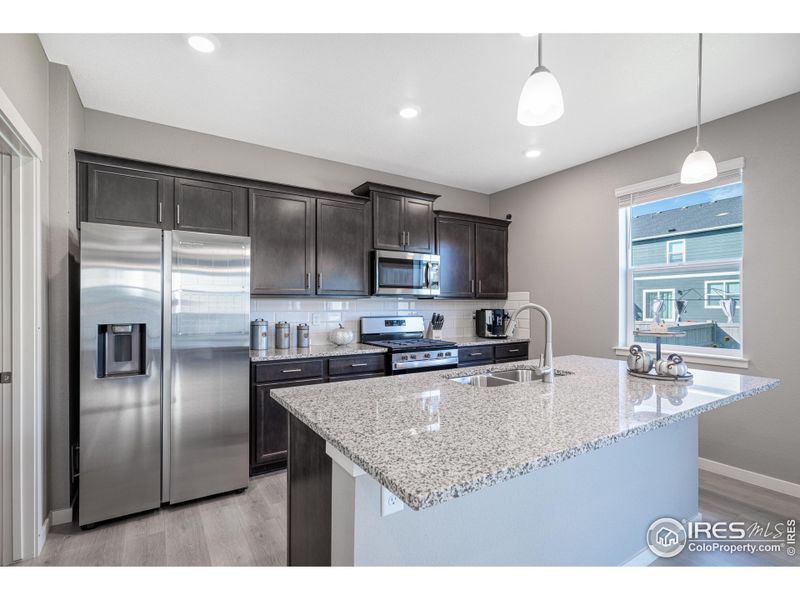 Kitchen features granite counters and a gas stove.