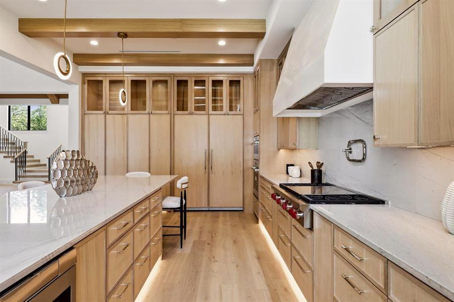 The chef’s kitchen is a masterpiece, featuring a Wolf steam oven, a built-in Miele coffee maker, Bianco Superiore Quartzite countertops, a 48-inch range, and SubZero refrigerator and freezer units