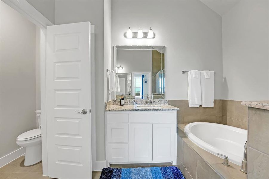 Full bathroom with a garden tub, vanity, and light tile patterned flooring