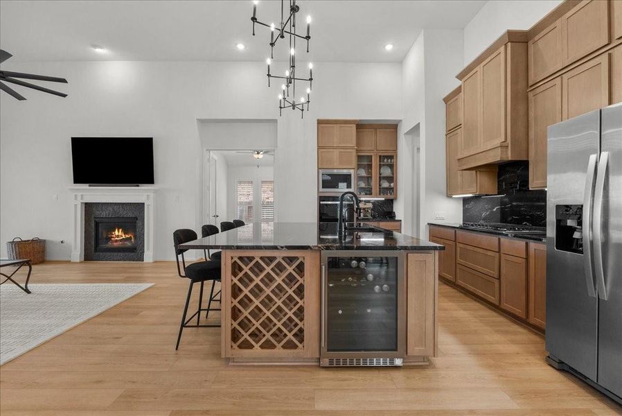 Chef’s kitchen overlooks the spacious living area and boasts double ovens, pot filler, granite countertops, designer backsplash, upgraded cabinetry, stainless steel appliances, stylish finishes, and oversized island seating.