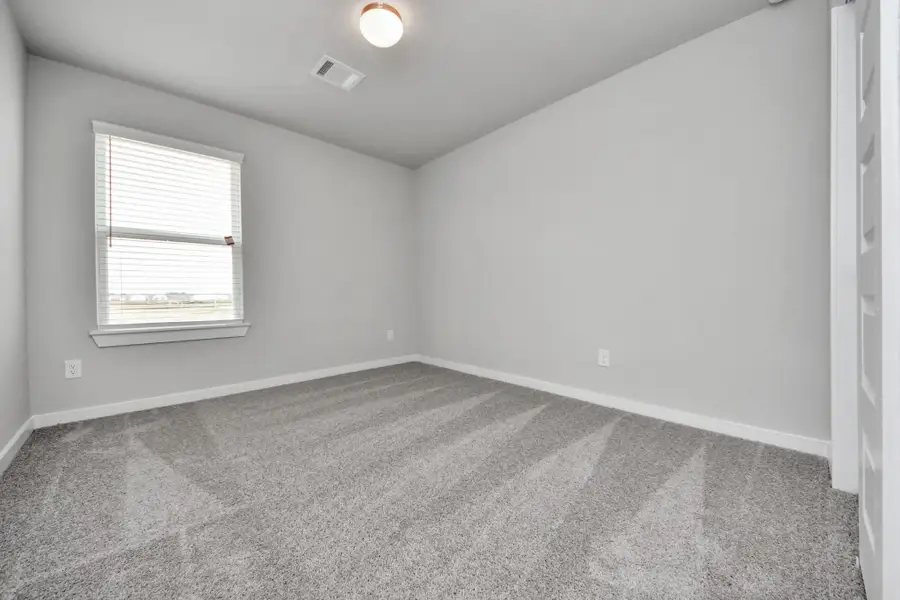 Generously sized secondary bedrooms featuring spacious closets, soft and inviting carpeting underfoot, large windows allowing plenty of natural light, and the added touch of privacy blinds for your personal retreat. Sample photo of completed home with similar floor plan. Actual colors and selections may vary.