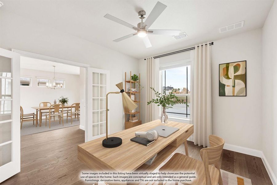 Home office with wood desk, ceiling fan, and French doors opening to dining room