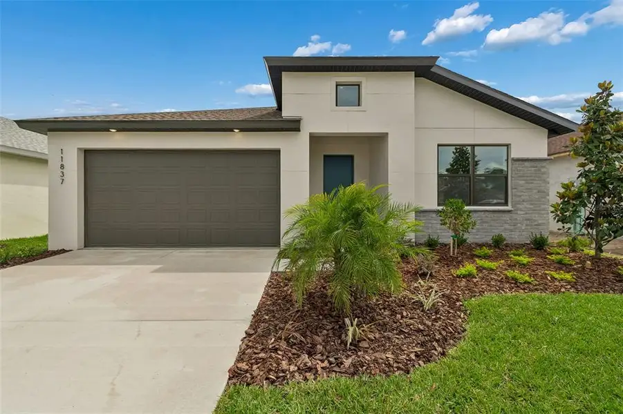 Front exterior of a new home in Isles at Bayview, Parrish, FL, highlighting curb appeal (Image 2). Front exterior of a new home in Isles at Bayview, Parrish, FL, highlighting curb appeal (Image 2).