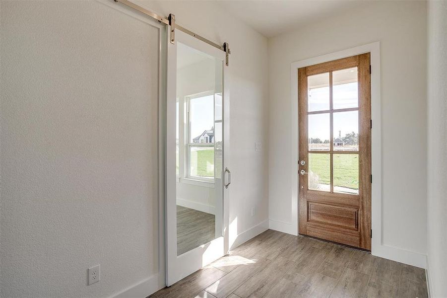 Entryway featuring light wood-type flooring and a barn door