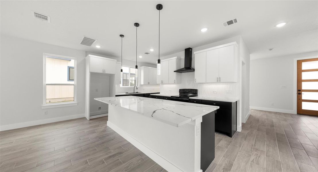 Kitchen featuring white cabinetry, wall chimney exhaust hood, light wood-type flooring, black electric range oven, and a kitchen island