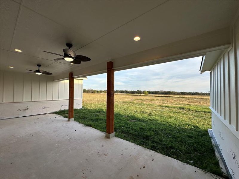 View of patio / terrace with ceiling fan and a rural view