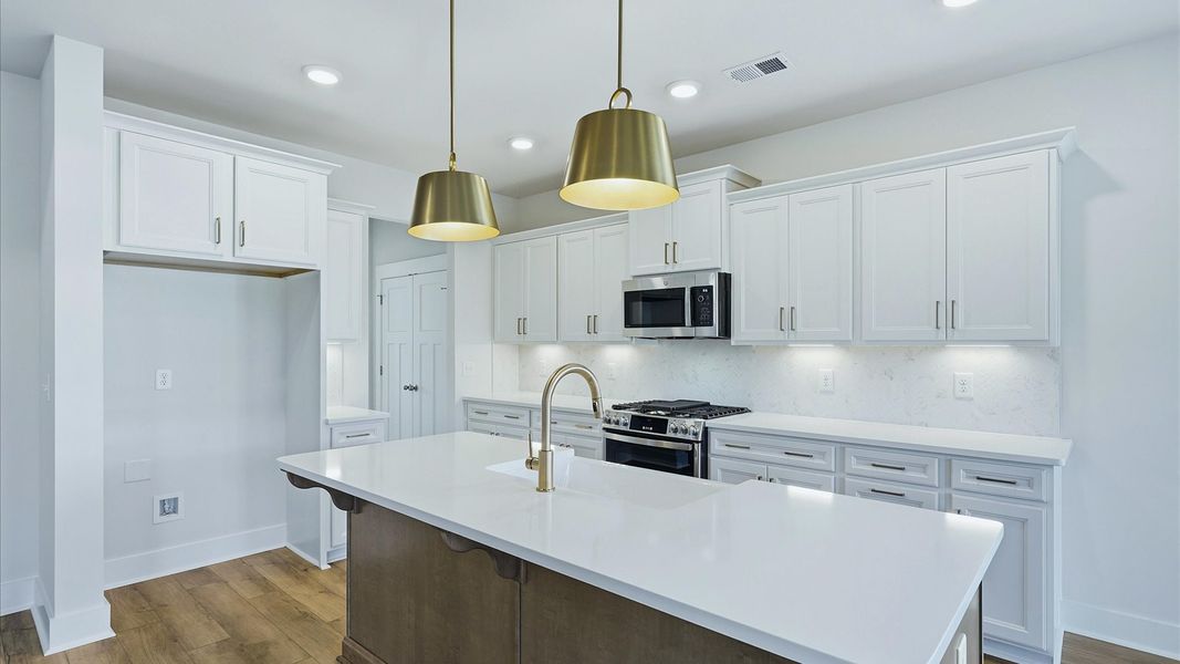 Exclusive DRB Homes kitchen with a 9-foot island, elevated finishes, and pendant lighting in a prime location