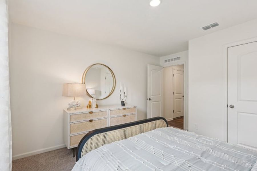 A bedroom with a mirror and a bed.