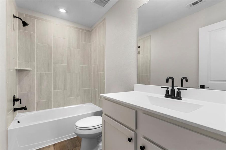 The upstairs secondary bathroom features tiled shower/tub combination.