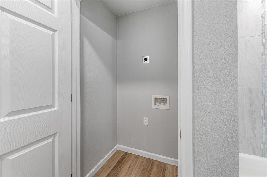 Laundry room with electric dryer hookup, wood finished floors, washer hookup, and baseboards Laundry room with electric dryer hookup, wood finished floors, washer hookup, and baseboards