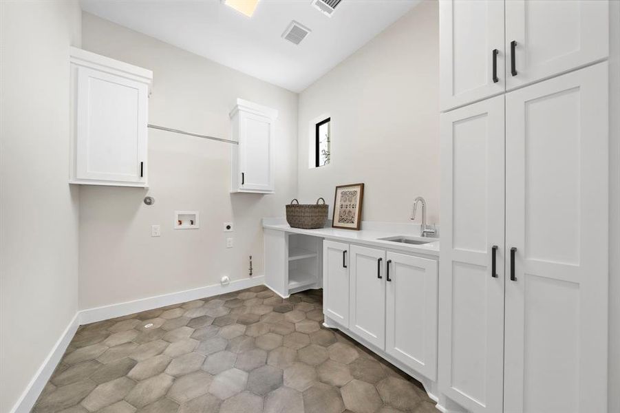 Everyone will enjoy doing laundry in this space! Located on the second floor this room has hex floor tiles, hanging rod and sink. The niche below is ideal for hiding a laundry basket or pet crate!