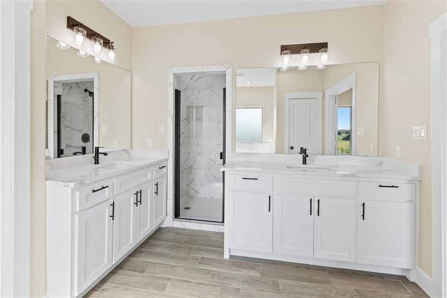 Bathroom featuring vanity and a shower with door