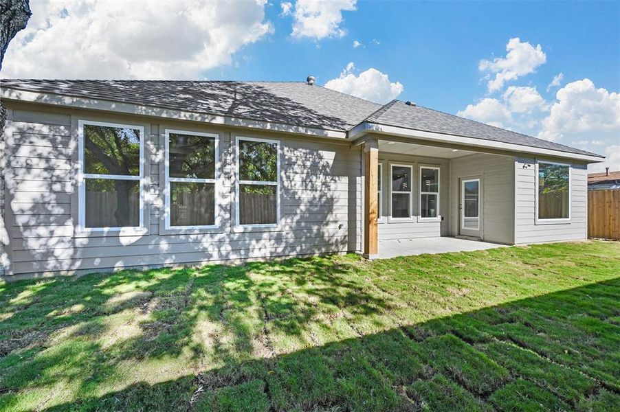 Back of property with a yard and a patio