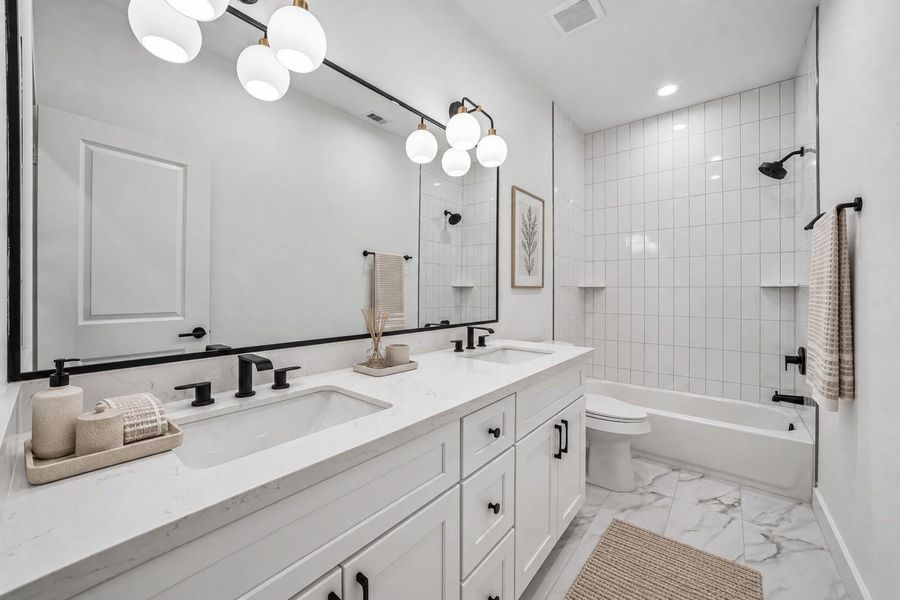 Secondary Bath. Tub & Shower combo with tile surround up to the ceiling. Modern fixtures.