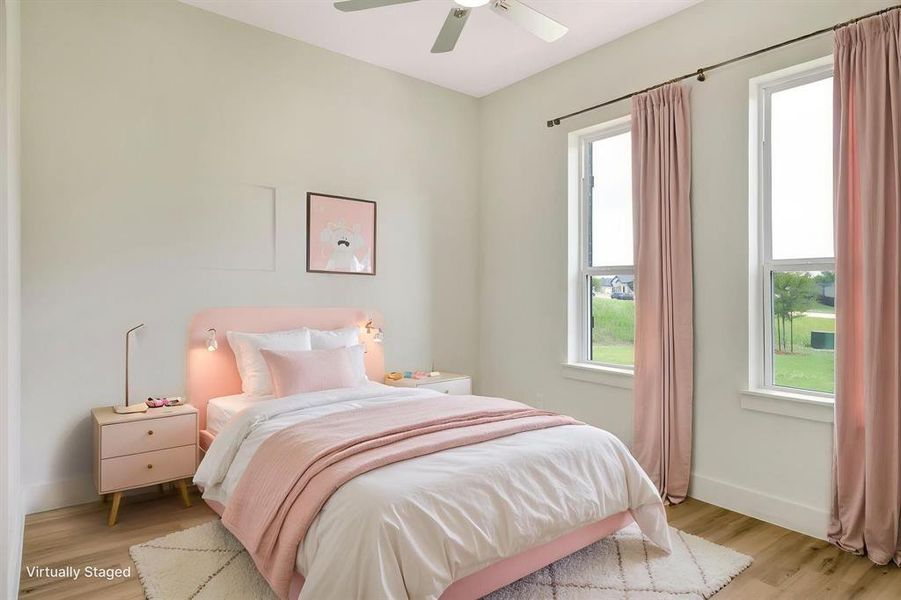 Spacious room with wood-finish flooring, light-toned walls, and a ceiling fan Spacious room with wood-finish flooring, light-toned walls, and a ceiling fan