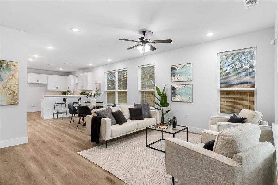 Living room with ceiling fan and light wood-type flooring