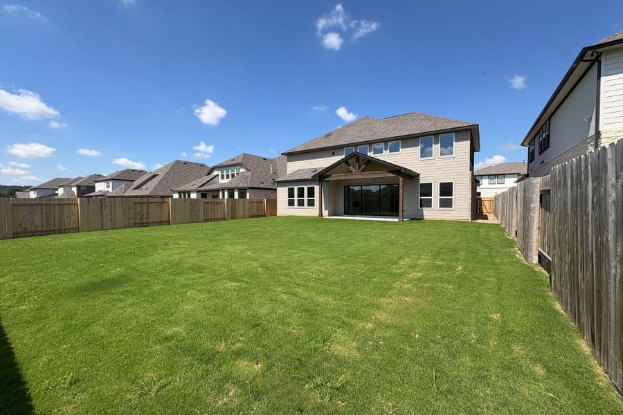 Expansive green lawn with a privacy fence