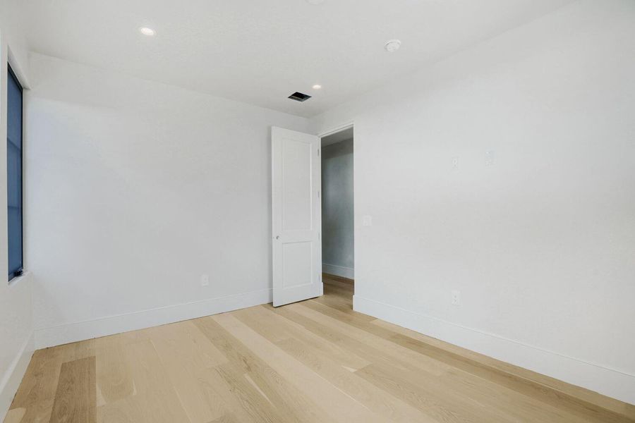 Blonde hardwood flooring sets a bright foundation for this pristine, open room.