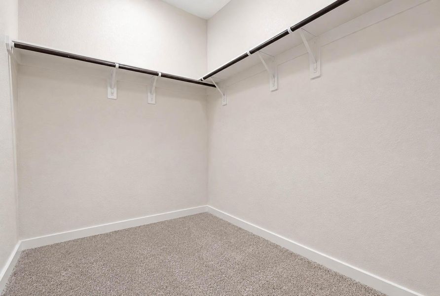 Generously sized walk-in closet provides excellent storage with wraparound shelving and hanging rods along multiple walls. The spacious footprint offers room to organize clothing, shoes, accessories, and seasonal items while keeping everything conveniently accessible from the primary suite. Generously sized walk-in closet provides excellent storage with wraparound shelving and hanging rods along multiple walls. The spacious footprint offers room to organize clothing, shoes, accessories, and seasonal items while keeping everything conveniently accessible from the primary suite.
