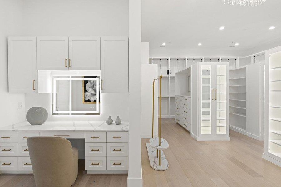 Custom cabinetry and generous storage options create an organized and chic walk-in wardrobe.
