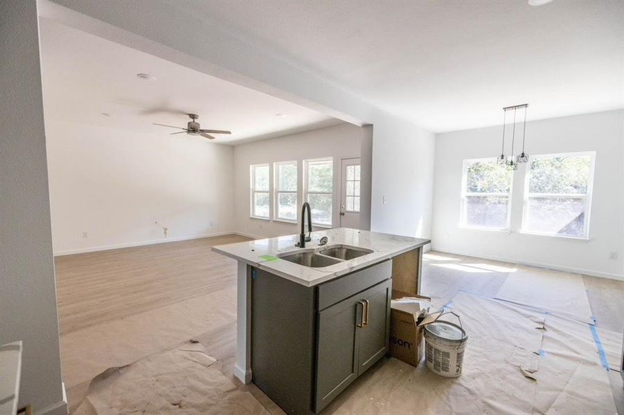 Kitchen featuring sink, light hardwood / wood-style floors, a wealth of natural light, and decorative light fixtures