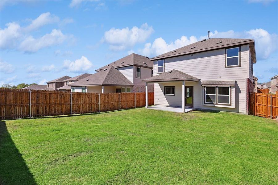 Back of property featuring a lawn and a patio area