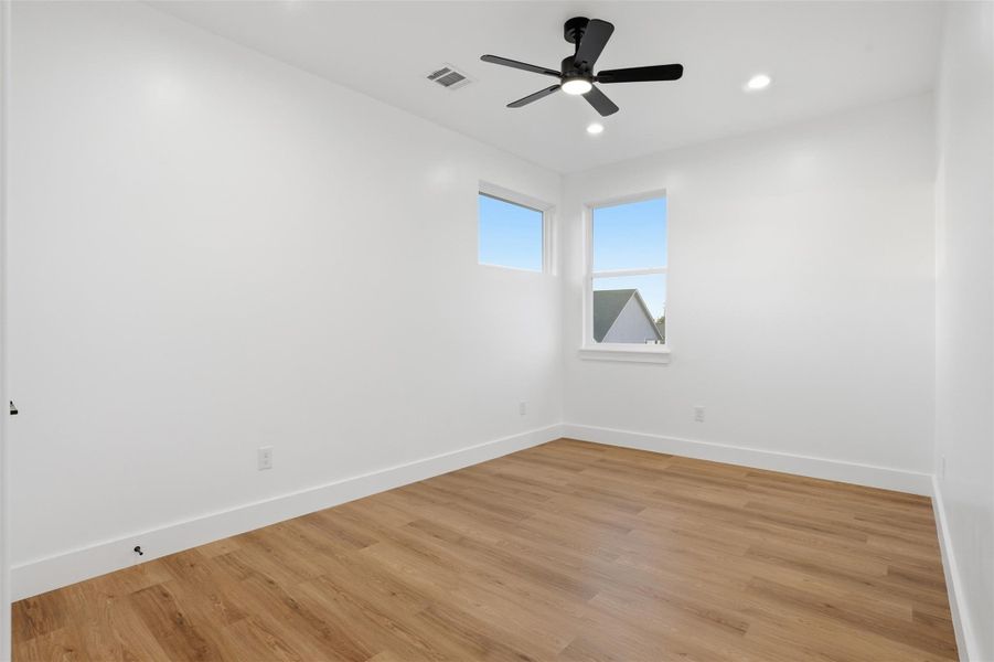 Empty room with light wood-type flooring, ceiling fan, and recessed lighting