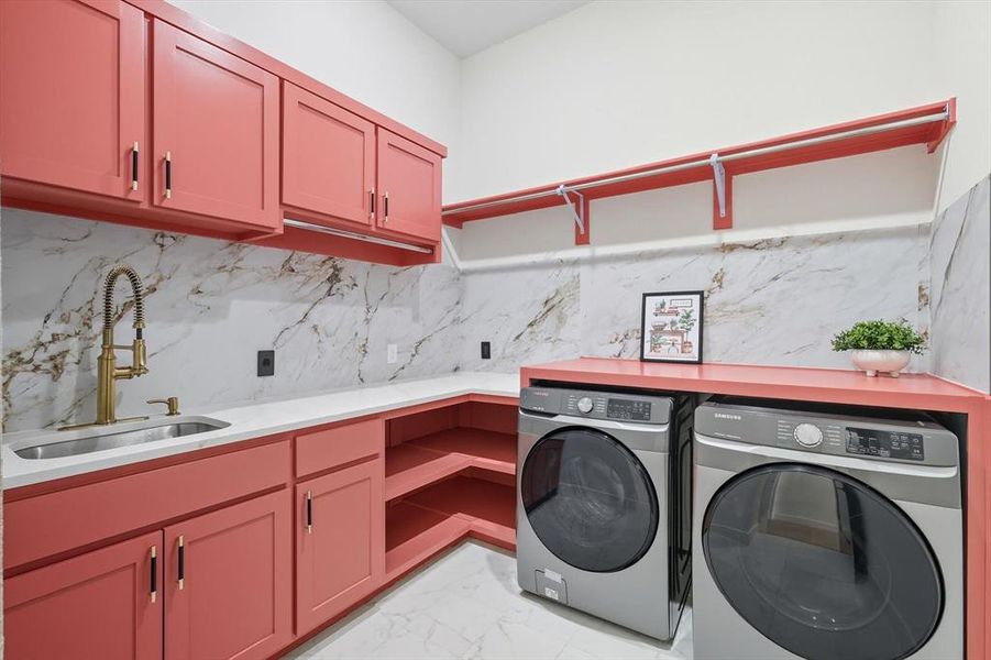 1st floor laundry area with light marble finish flooring, washer and dryer, built-in cabinets, & sink 1st floor laundry area with light marble finish flooring, washer and dryer, built-in cabinets, & sink