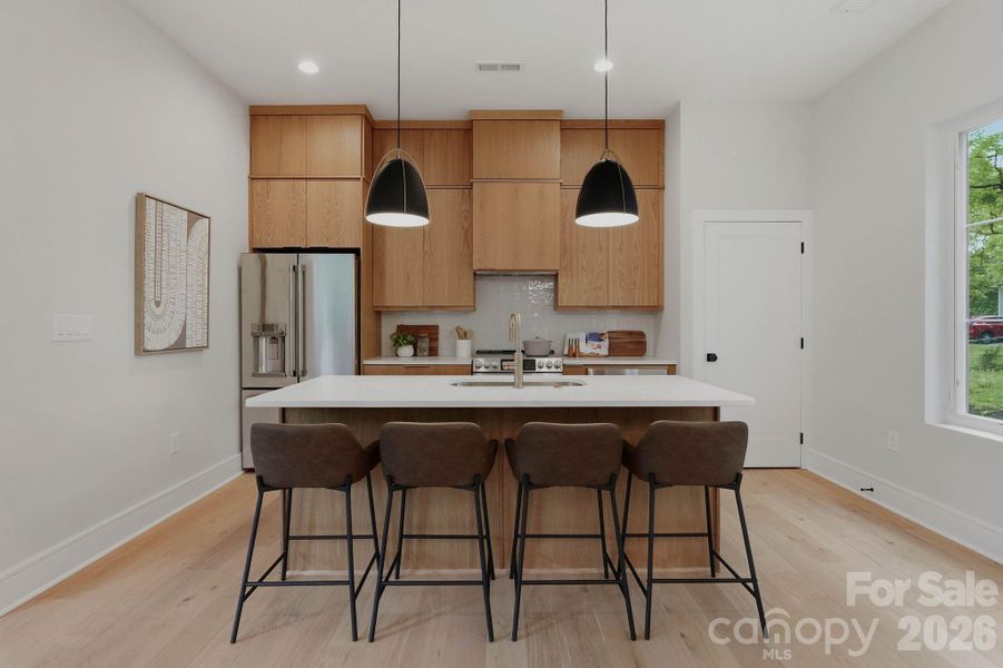 Custom white oak cabinetry with GE Cafe Series appliances with a large pantry.