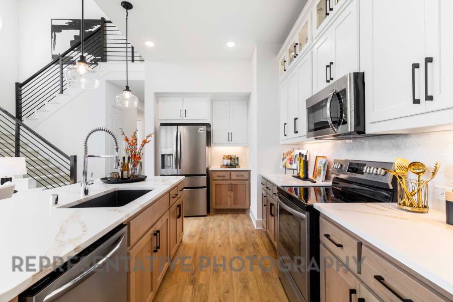Kitchen featuring decorative backsplash, stainless steel appliances, a sink, light wood-type flooring, and pendant lighting Kitchen featuring decorative backsplash, stainless steel appliances, a sink, light wood-type flooring, and pendant lighting
