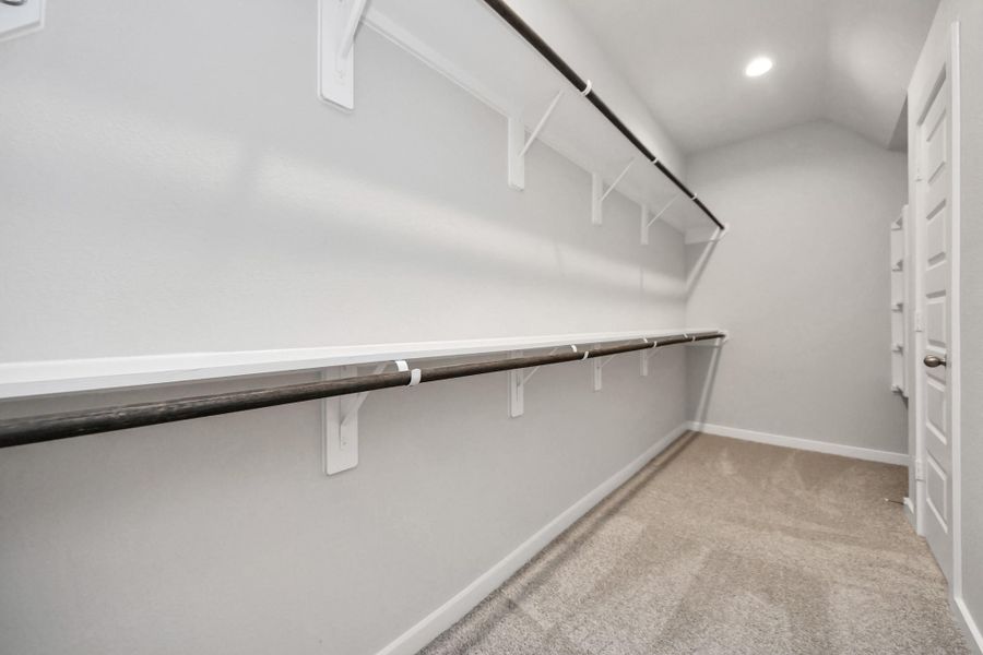 Walk-in closet that epitomizes luxury and practicality. This generously sizedspace features built-in shelving, offering abundant room for impeccableorganization. High ceilings and recessed lighting create a bright andwelcoming ambiance.