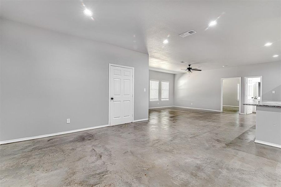 Unfurnished room with concrete floors and ceiling fan