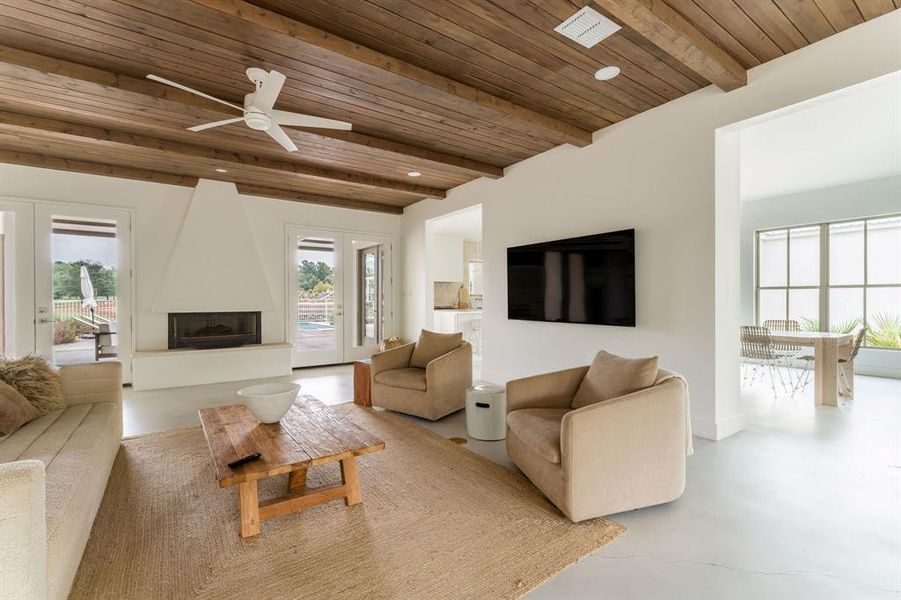 Living room with finished concrete floors, beam ceiling, and stairway Living room with finished concrete floors, beam ceiling, and stairway