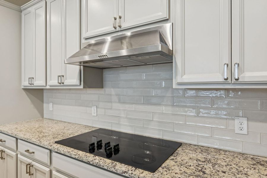 Kitchen with modern back splash and electric stovetop