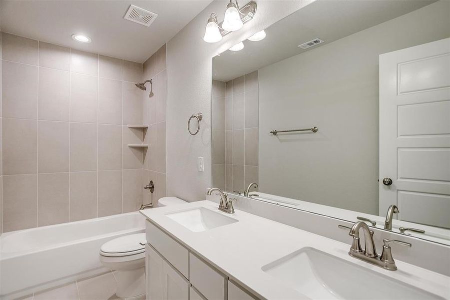 Bathroom featuring double vanity, shower / washtub combination, light tile patterned floors, and recessed lighting Bathroom featuring double vanity, shower / washtub combination, light tile patterned floors, and recessed lighting