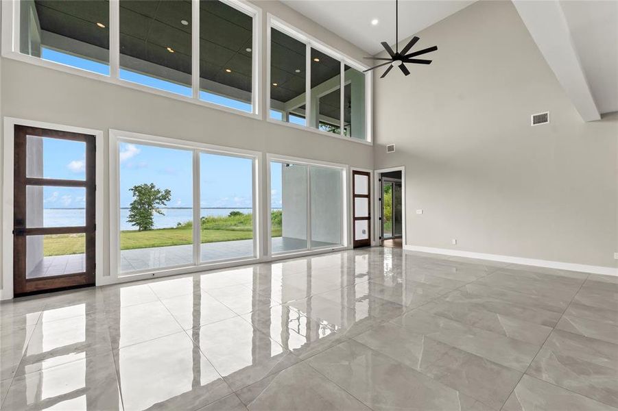 A dramatic two-story wall of glass frames expansive open water views and fills the living space with natural light.
